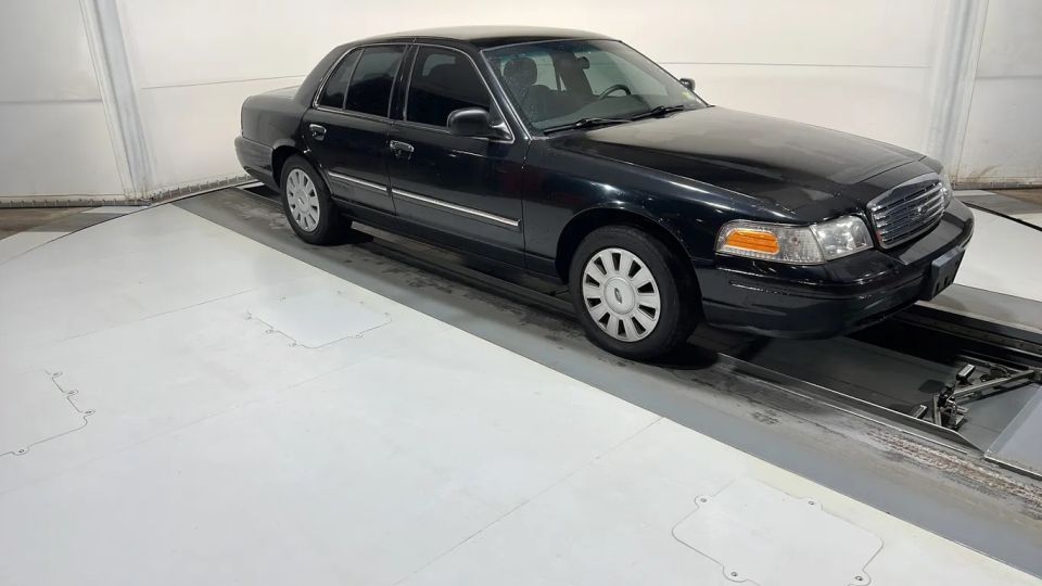Black Ford Crown Victoria on a lift, front 3/4 view