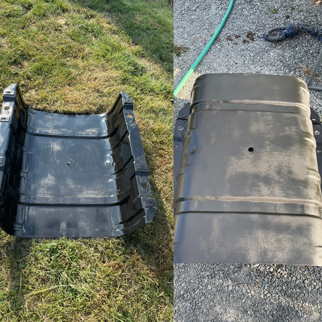 Fuel tank and black plastic skid plate on gravel and grass