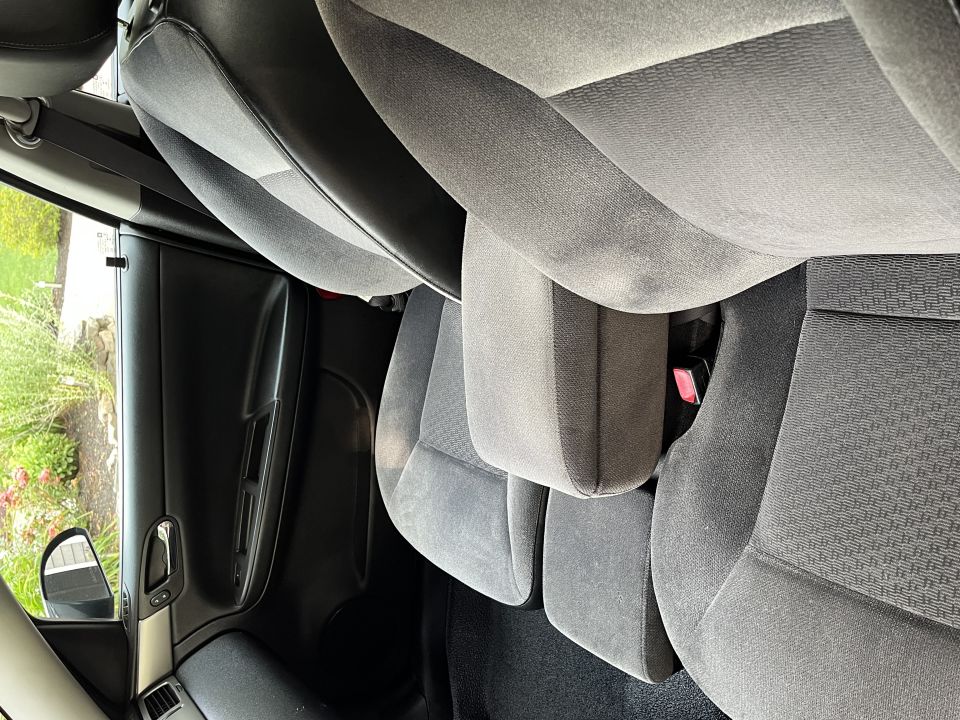 Interior view of grey fabric rear car seats and door panel.