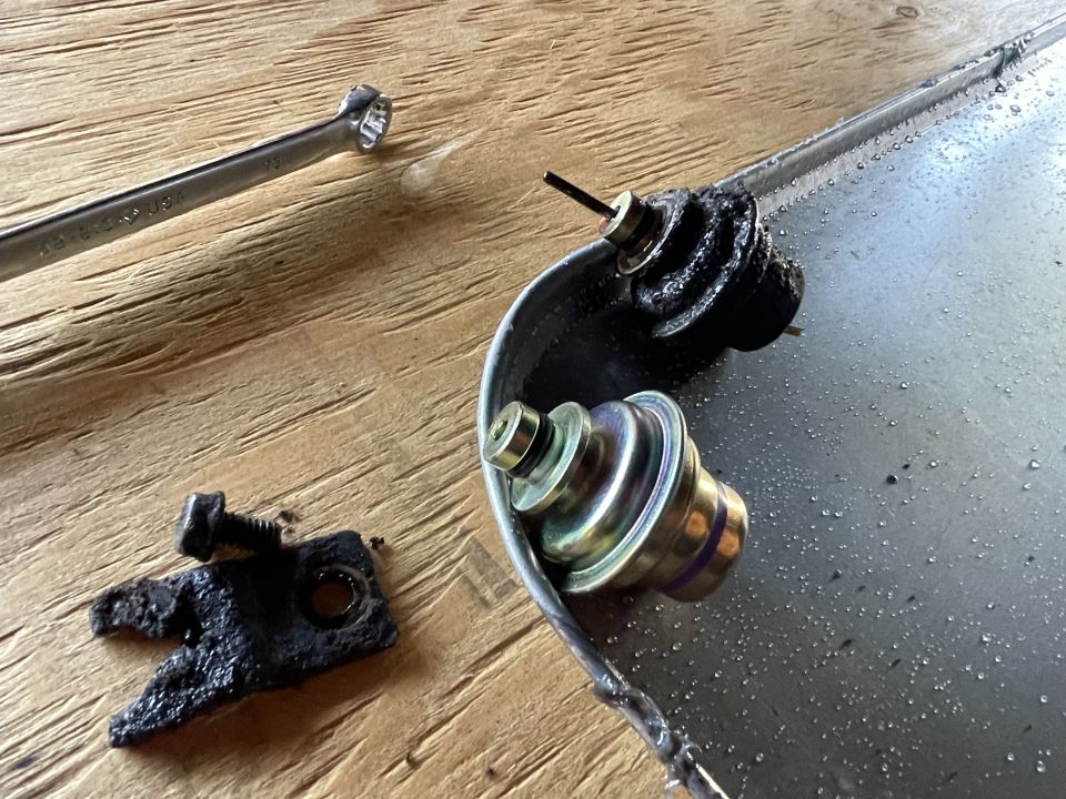 Vehicle parts with rubber seals and a wrench on a wooden surface.