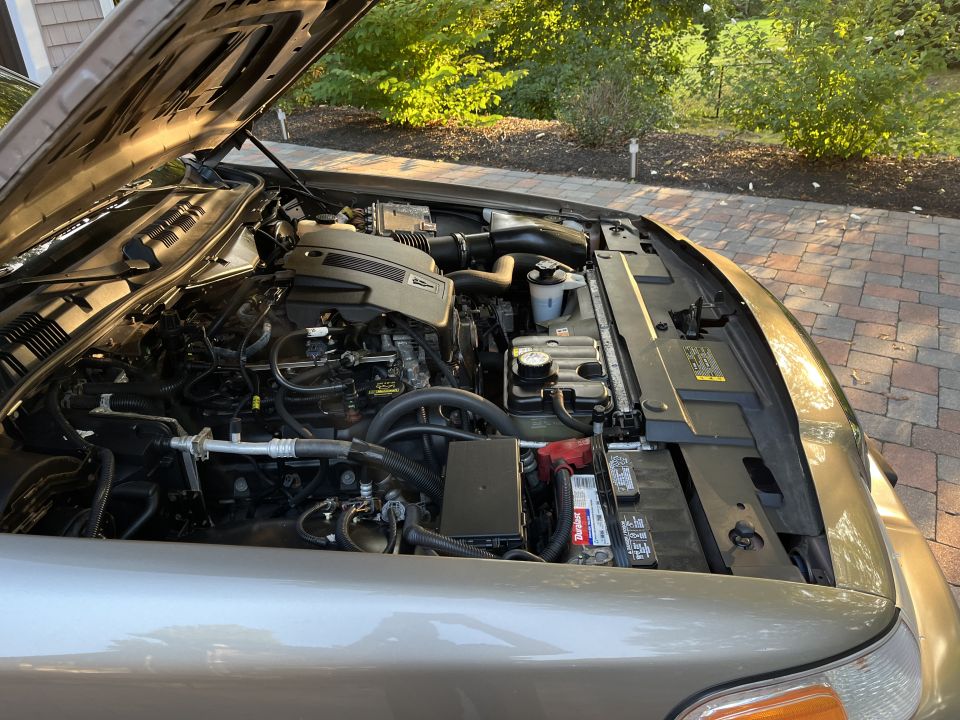 Side view of an open engine bay on a Ford Crown Victoria in a driveway