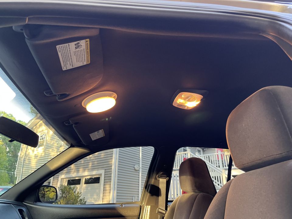 Car headliner with lit dome and map lights and sun visor