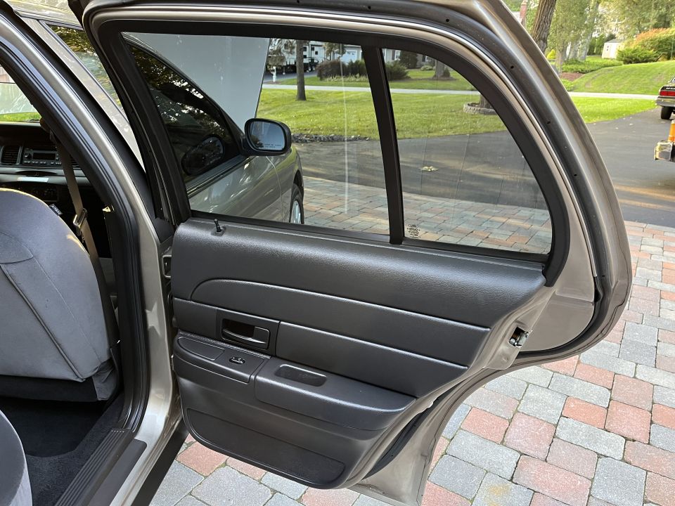 Open rear door of a Ford sedan showing rear door panel
