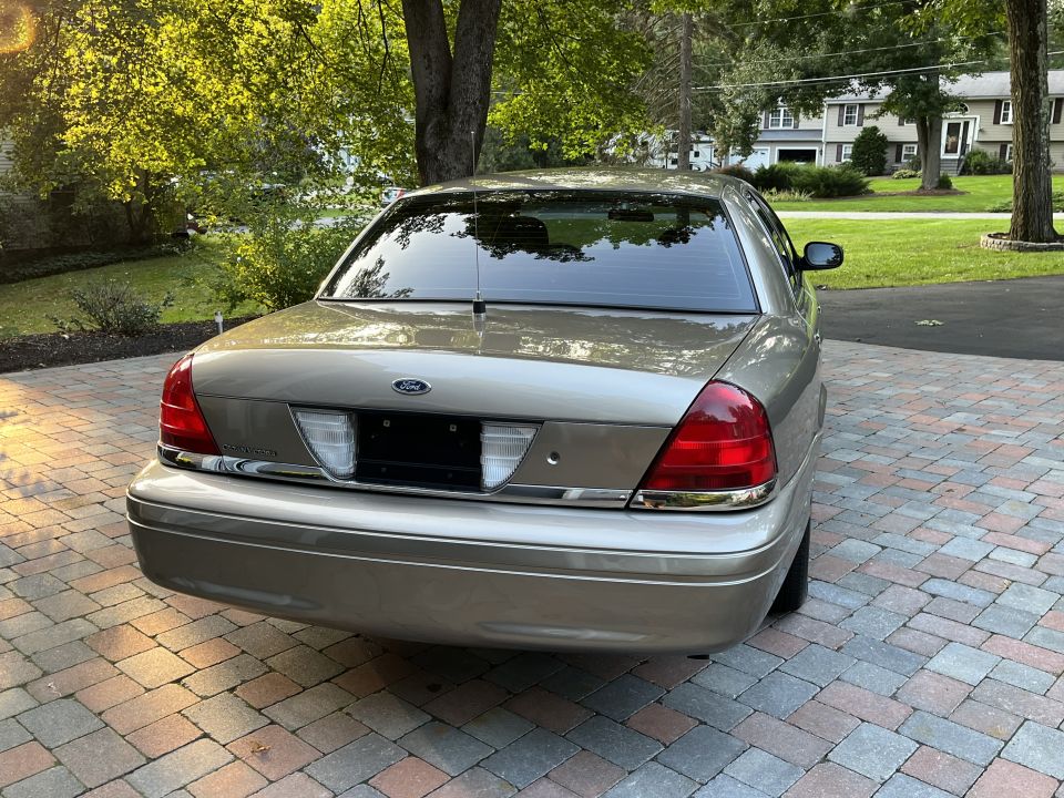 Rear view of a tan Ford Crown Victoria with taillights and trunk