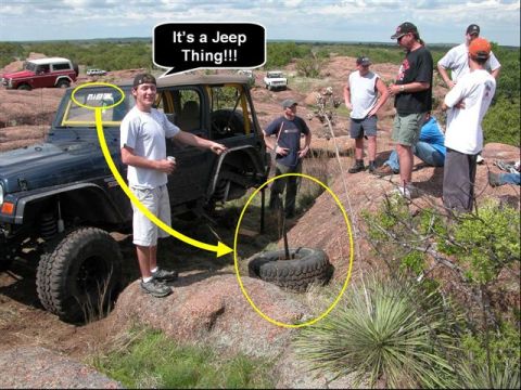 1973 Ford Bronco - A group of people are gathered around a Jeep Wrangler in a rocky, outdoor environment.