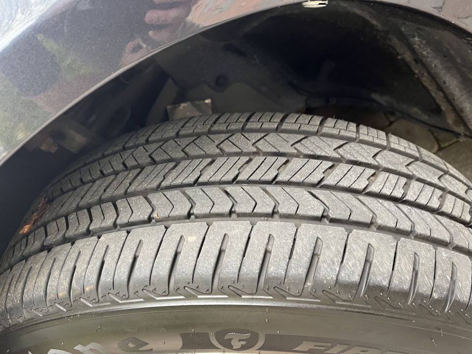 Close-up photo of a tire tread and sidewall in the wheel well