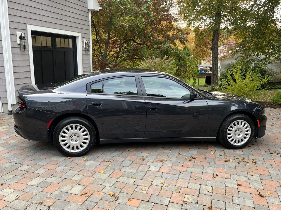 Driver-side profile of a dark Dodge Charger sedan