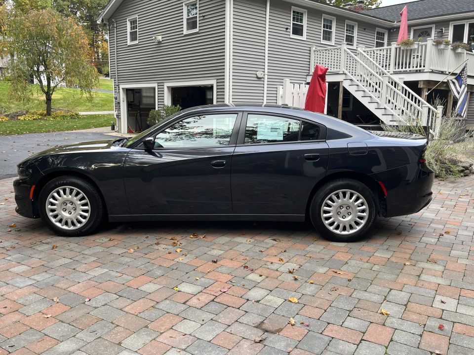 Driver-side profile of a black Dodge Charger in a driveway