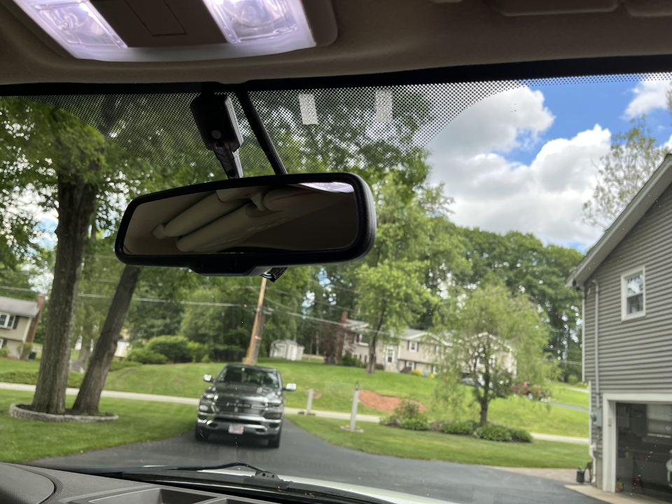 View through windshield and rearview mirror with pickup truck outside