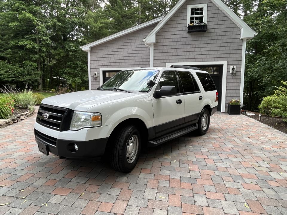 Front three-quarter view of white Ford Expedition with running boards