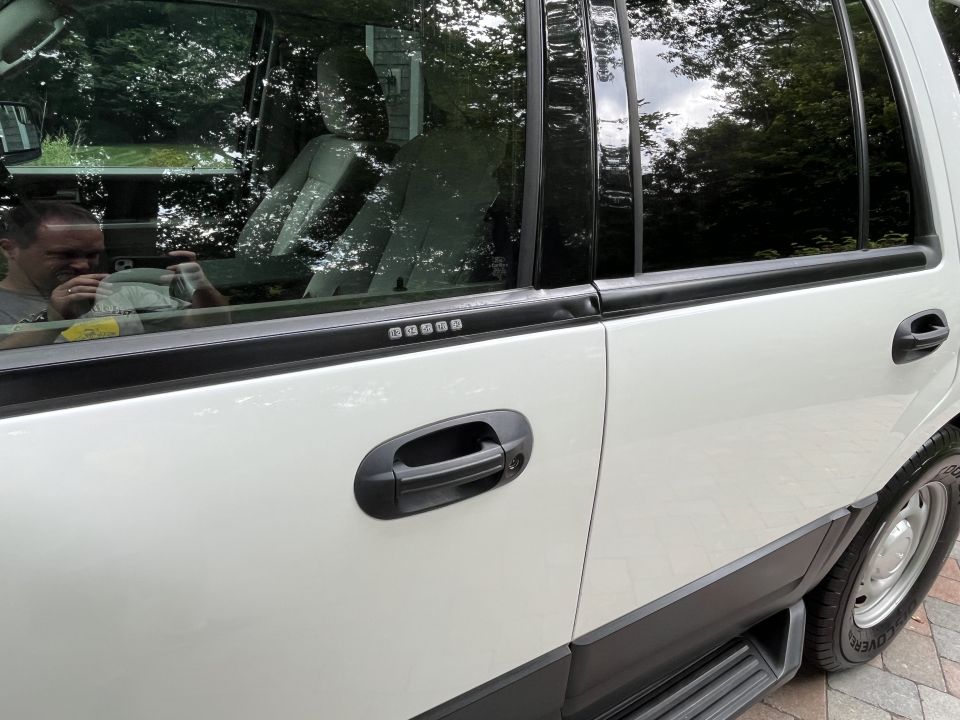 Rear passenger door and window detail of white Ford Expedition