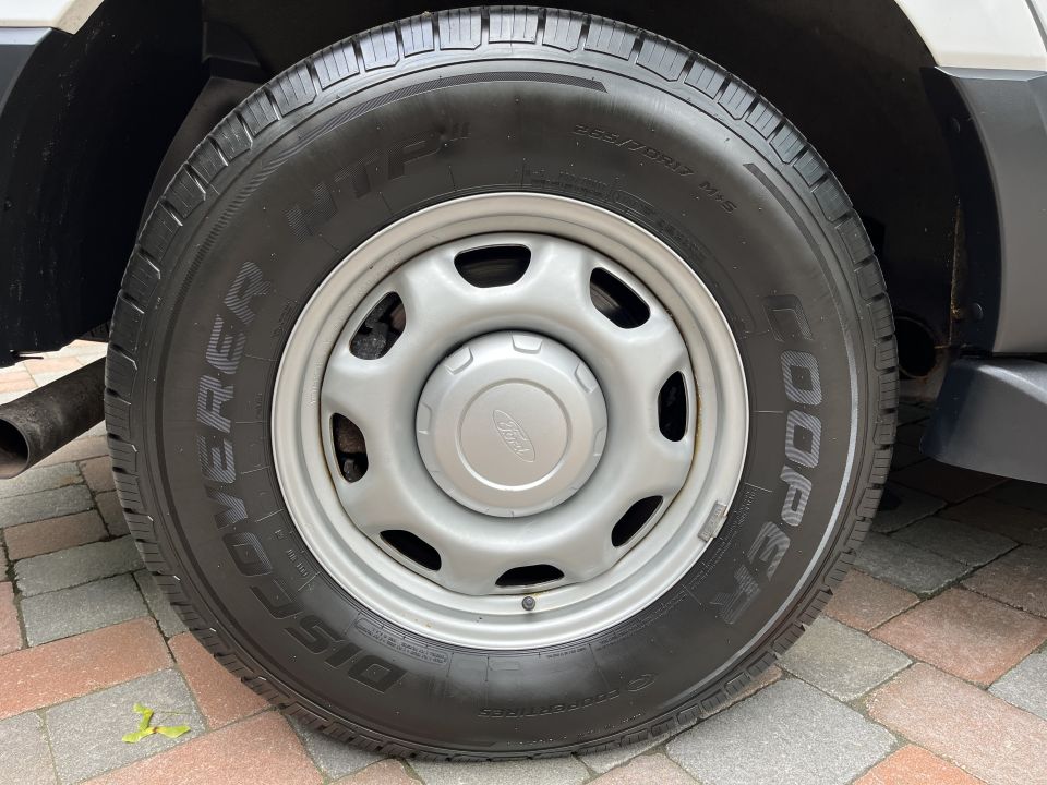 Wheel with Cooper Discoverer tire on white Ford Expedition