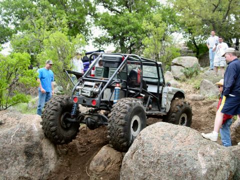 1973 Ford Bronco - Custom off-road buggy tackles challenging rocks during an event.