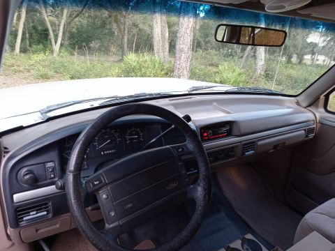 1994 Ford Bronco - The interior of a vehicle is captured, showing the dashboard, steering wheel, and windshield.