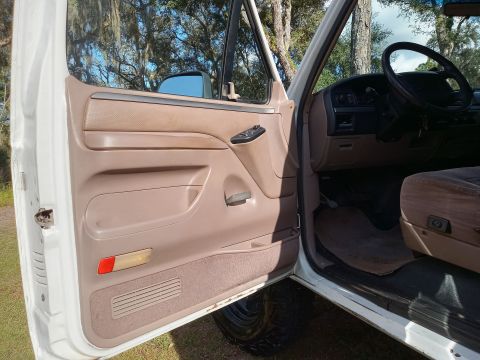 1994 Ford Bronco - The interior of a 1994 Ford Bronco, showing the driver's side door panel and dashboard.