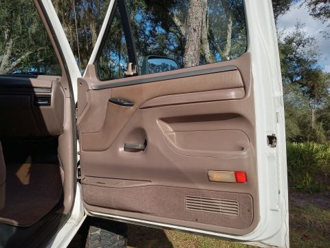 1994 Ford Bronco - Interior view of a 1994 Ford Bronco, focusing on the driver's side door panel and dashboard.
