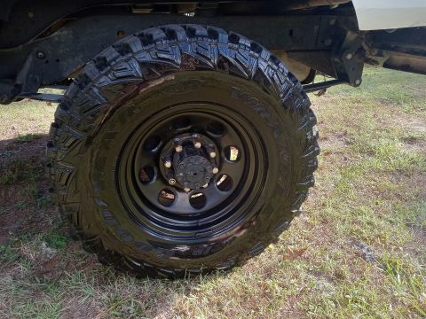 1994 Ford Bronco - A close-up view of a vehicle's tire and wheel, with the chassis visible above.