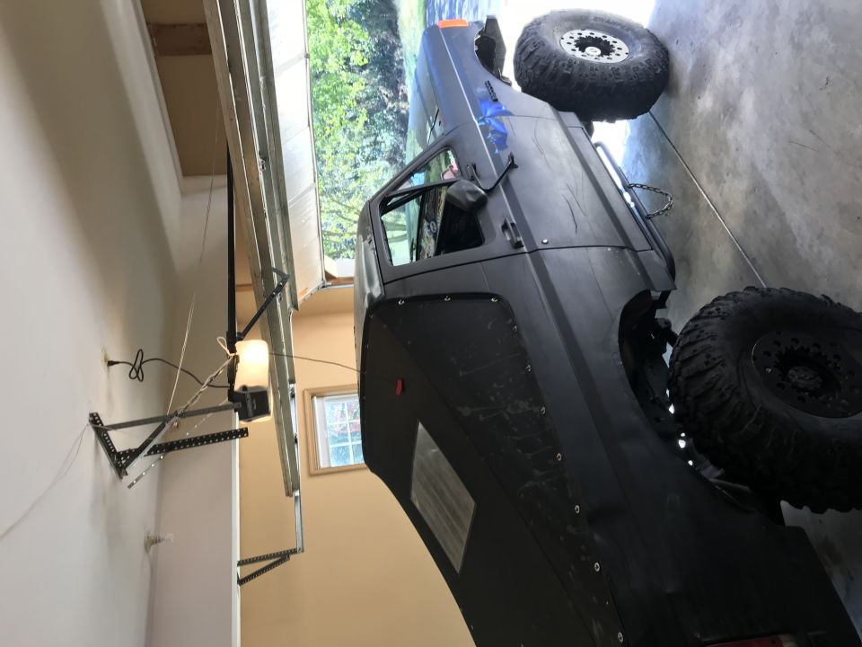 Black SUV with large tires and fender flares parked in a garage