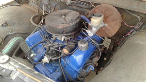 1961 Ford F-350 - The engine bay of a vehicle, a blue V8 engine with an air cleaner and various hoses and wires.