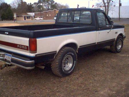 2000 Ford Escort - This Ford pickup truck is shown from the rear quarter angle, with its two-tone paint scheme and chrome bumper visible.