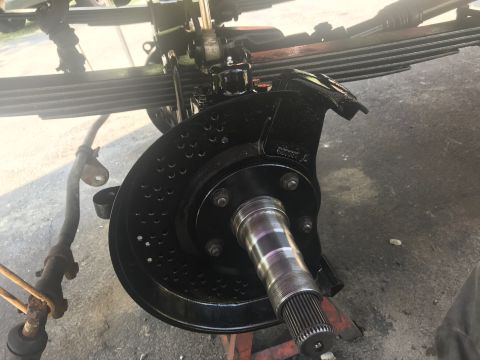 1985 Ford F-350 - Close-up of a vehicle's front axle assembly during a rebuild or paint process.
