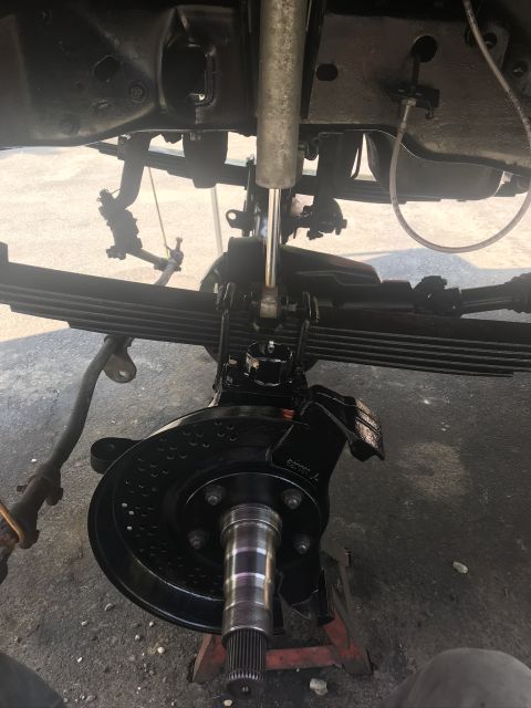 1985 Ford F-350 - Close-up view of a truck's front suspension and axle components, showing recent maintenance or restoration work.