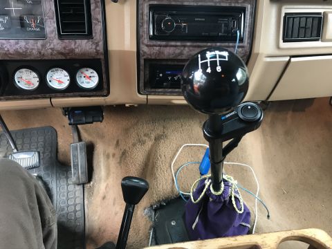 1985 Ford F-350 - Interior view of a truck's dashboard, showing gauges, a stereo, and a manual transmission shifter.