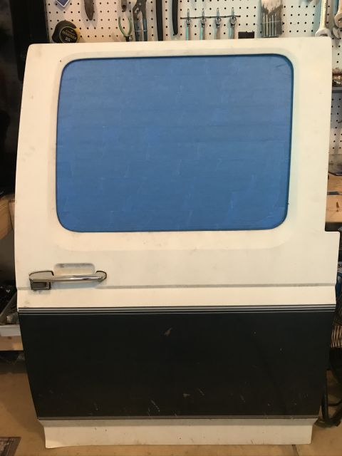 1985 Ford F-350 - A single van door, likely from a commercial vehicle, is shown with a blue tinted window and a two-tone lower section.