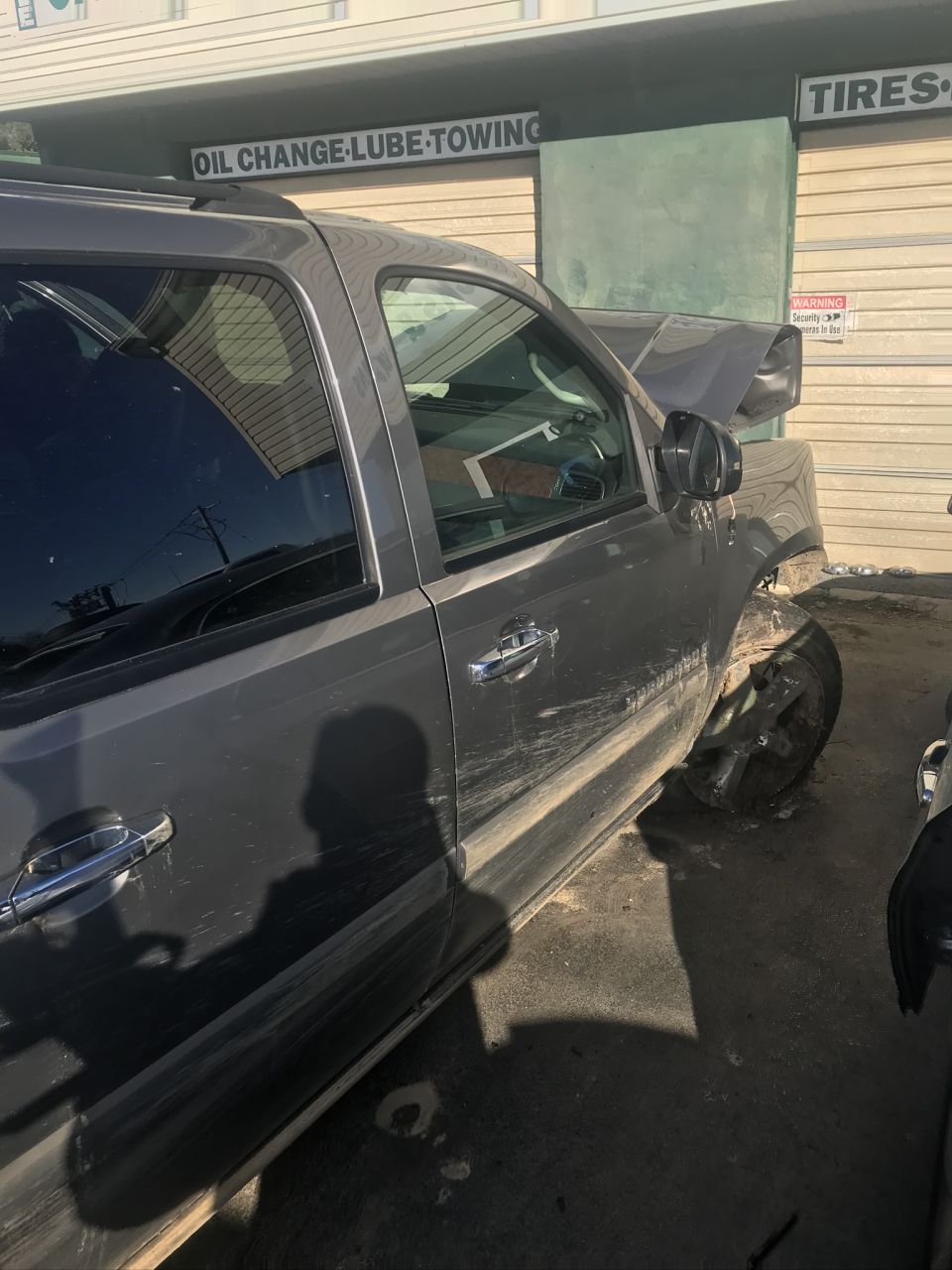 Gray SUV with front end damage, hood popped, and front passenger wheel askew