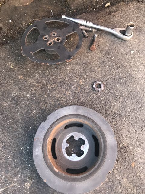 1985 Ford F-350 - Disassembled harmonic balancer and associated tools laid out on a concrete surface.