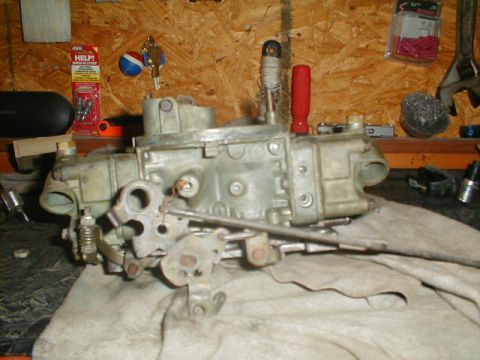 1967 Ford Mustang - A close-up view of a carburetor, likely for an older vehicle, resting on a cloth on a workbench.