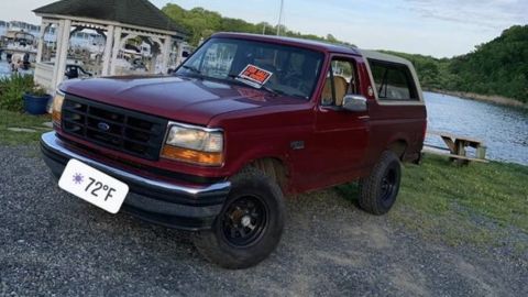 1994 Ford Bronco - This 1994 Ford Bronco is parked near a body of water with a gazebo in the background.