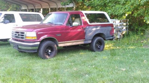 1994 Ford Bronco - This 1994 Ford Bronco is seen parked on a grassy area next to another vehicle.