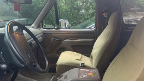 1994 Ford Bronco - The interior of a vehicle is shown, the driver's side controls and passenger seats.