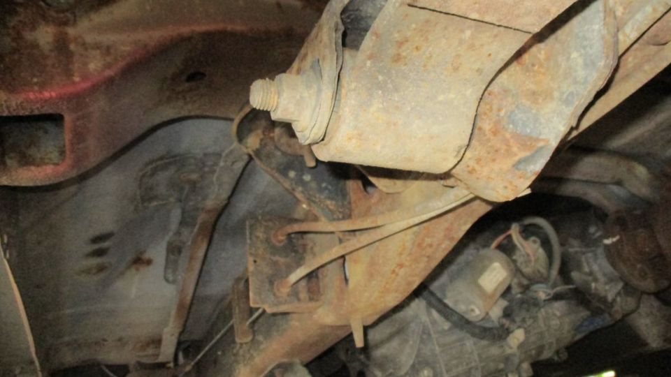 Underbody view of rusty suspension components and drivetrain