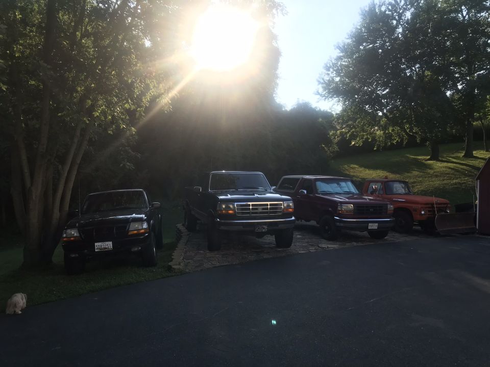 Four pickup trucks parked in a driveway.