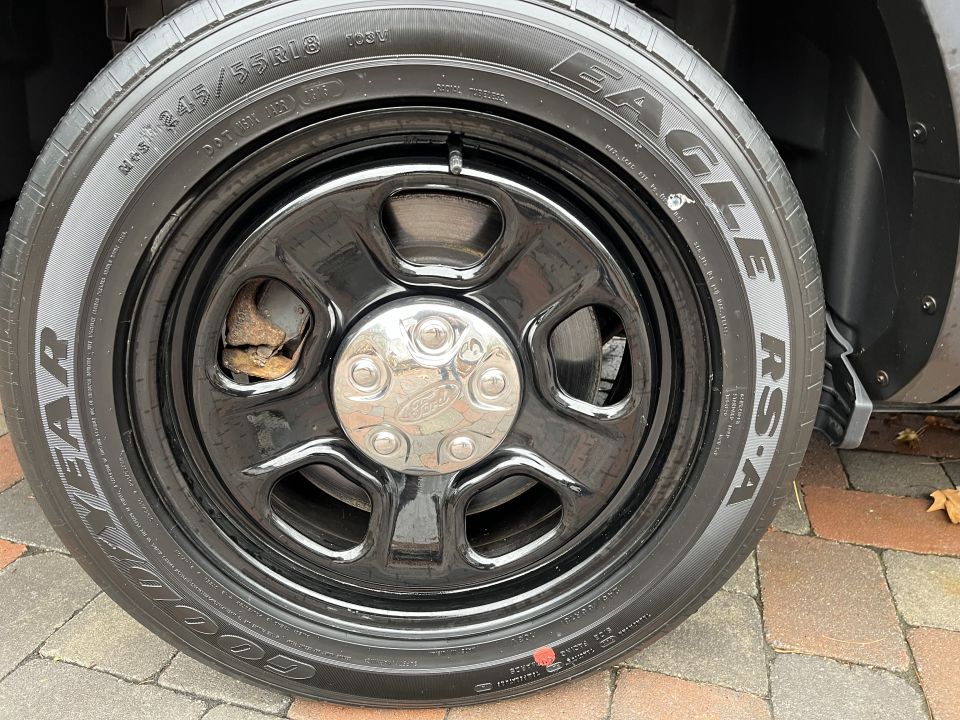 Close-up photo of a black steel wheel with Goodyear Eagle RS-A tire