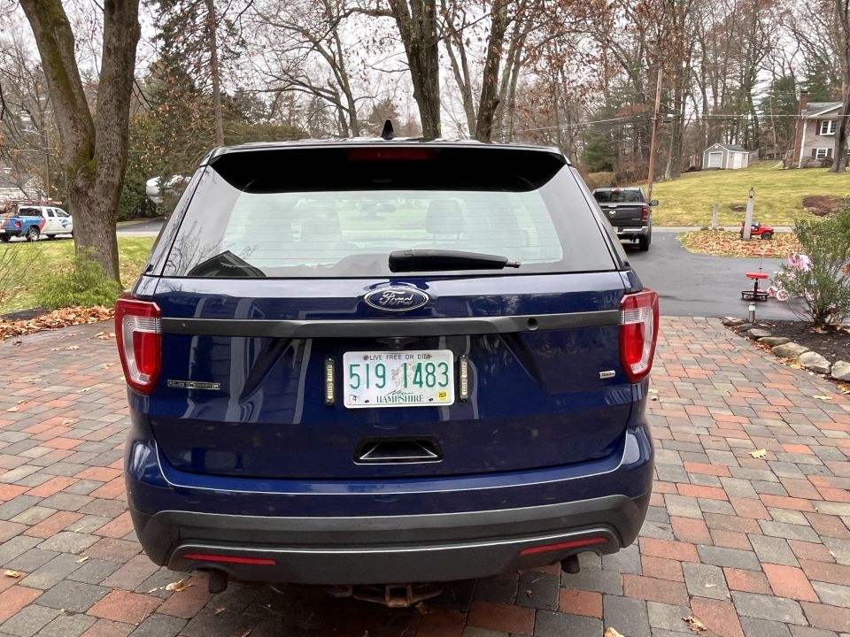 Rear photo of a blue Ford Explorer SUV with New Hampshire plate
