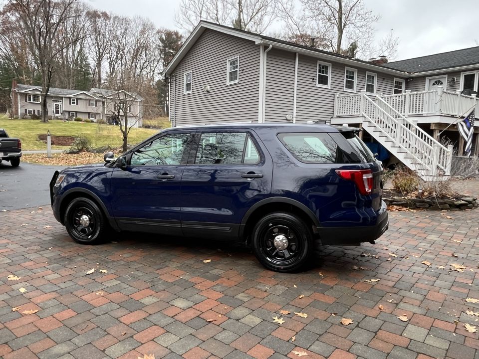 Side profile photo of a blue Ford Explorer SUV in a driveway
