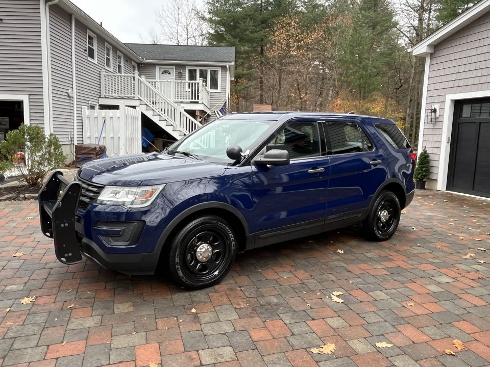 Dark blue Ford Police Interceptor Utility with push bar, front three-quarter view