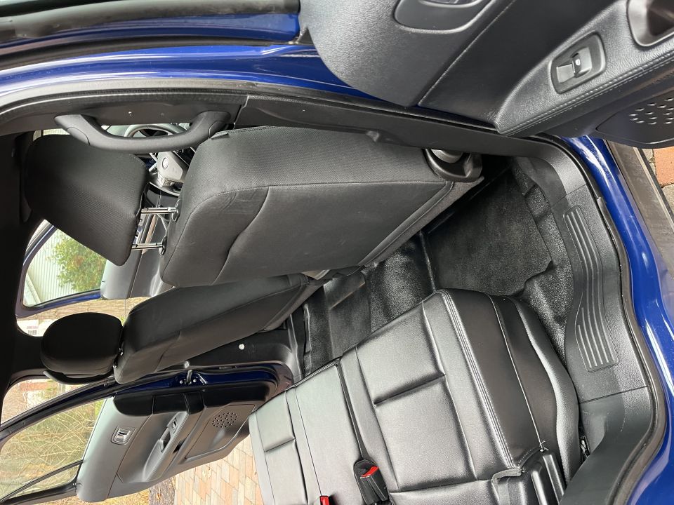 Folded rear seats and footwell inside a blue Ford Explorer
