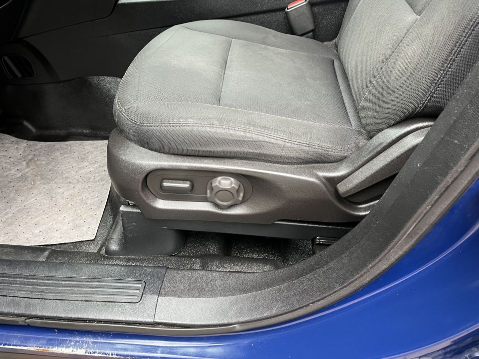 Front cloth seat with power-adjust controls on the lower side