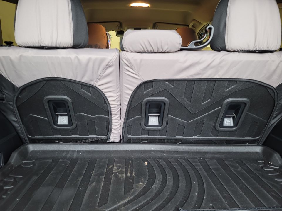 Rear interior of a Subaru Impreza showing seat covers, child seat anchors, and cargo mat.