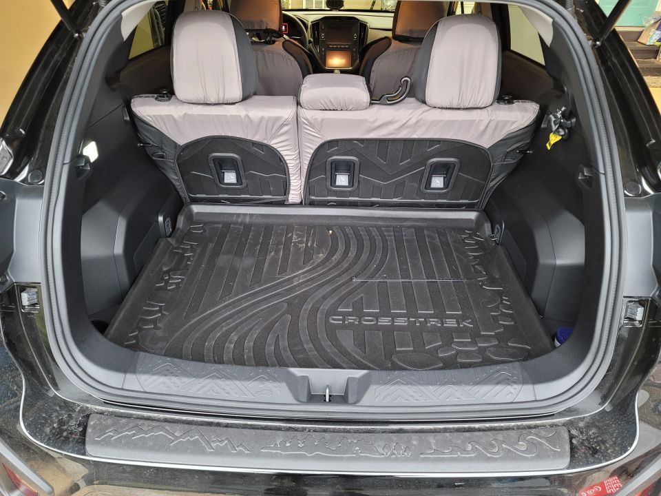 Black Subaru Crosstrek cargo area with all-weather floor mat and folded rear seats.