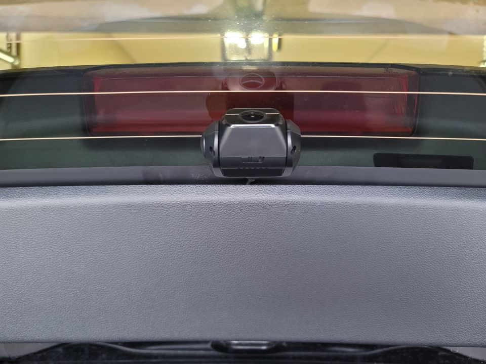 Dashcam mounted on the inside of a car's rear window.