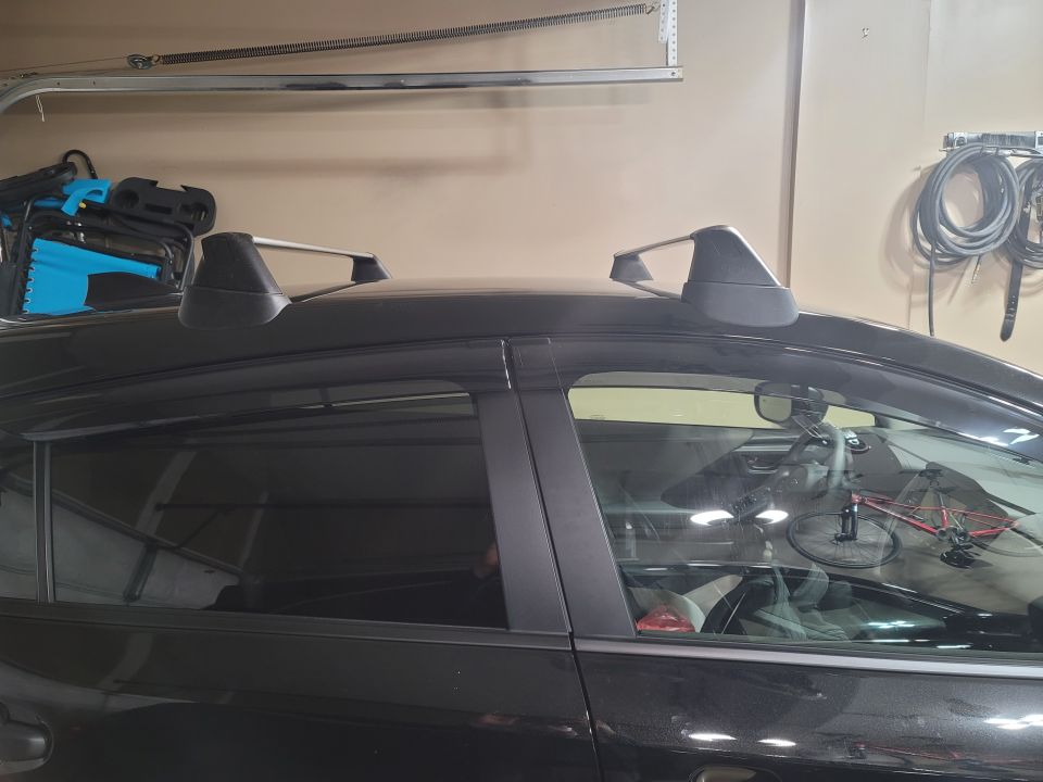 Black Subaru Impreza with silver roof rack and interior view of a red bicycle.