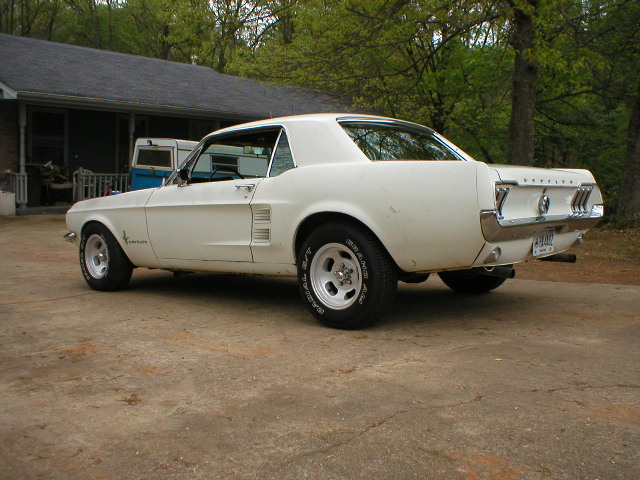 White 1967 Ford Mustang coupe, rear 3/4 view, aftermarket wheels