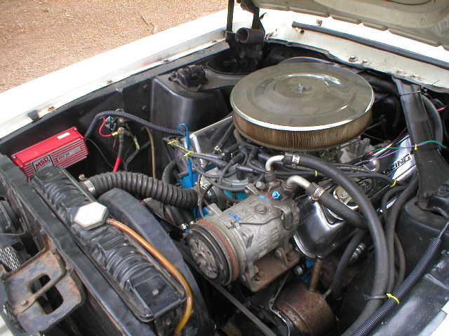 Engine bay with V8 engine, air cleaner, radiator, and AC compressor visible