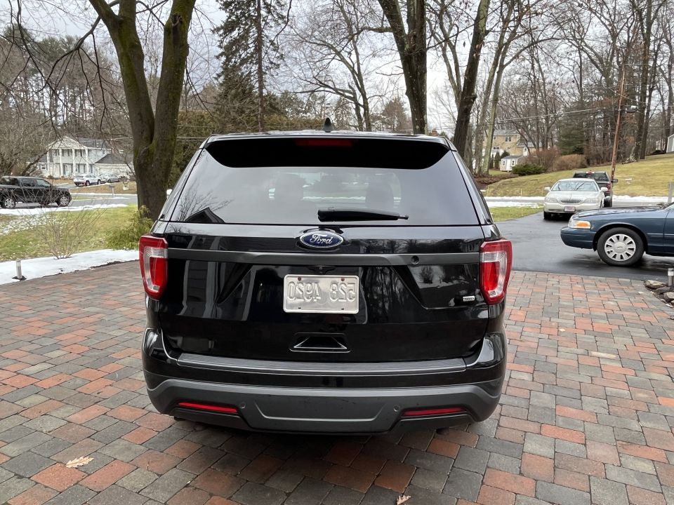 Black Ford Police Interceptor Utility rear view with license plate