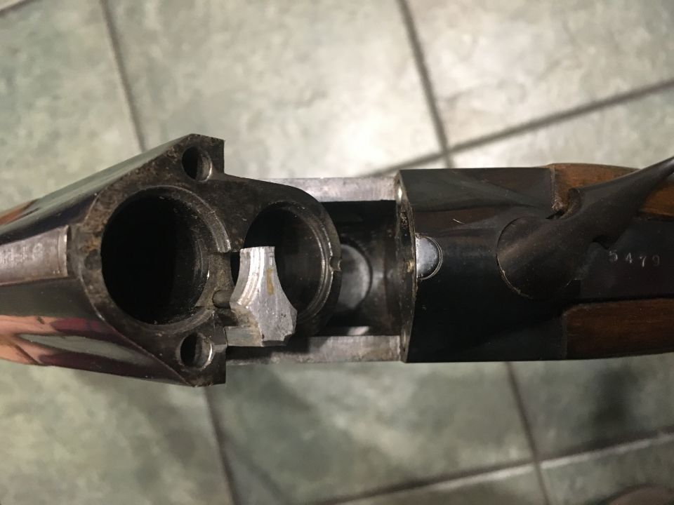 Close-up of a shotgun receiver with visible serial number 5479